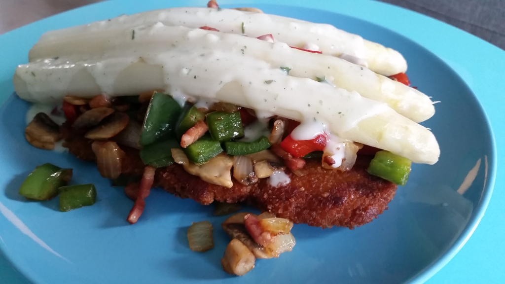 Witte asperges bovenop een boerenschnitzel met spekjes, paprika, ui en champignons