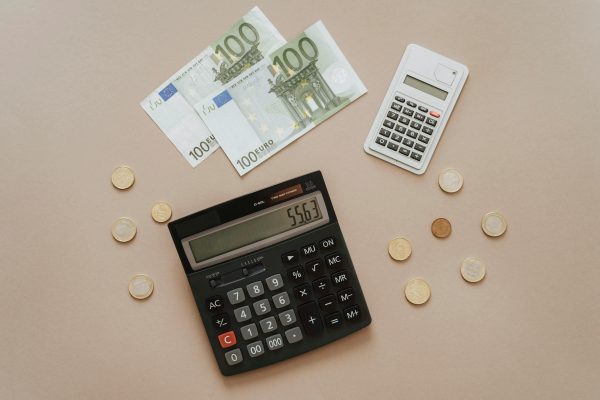 Rekenmachine, euro biljetten en euro punten op een tafel