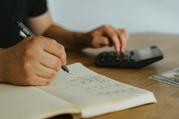 Vrouw met rekenmachine, geld en boekje