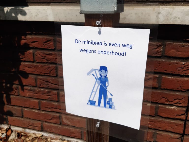Een briefje met 'De minibieb is tijdelijk weg in verband met onderhoud' voor onze buurtgenoten en bezoekers