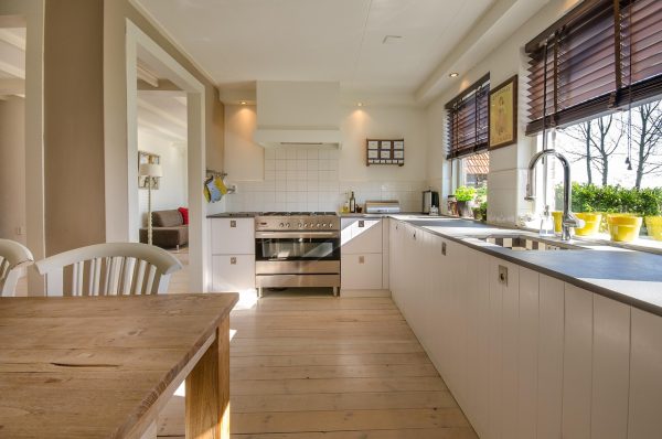 Foto van een ruime landelijke woonkeuken met veel wit en hout