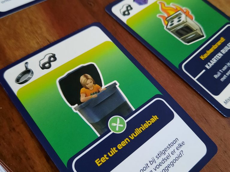 hoe ziet het Bordspel the Sims eruit: met actiekaarten vol herkenbare acties uit het spel. Zoals eten uit de vuilnisbak of brand in je keuken