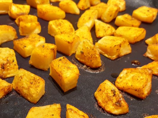 aardappels op een zwarte bakmat in de oven