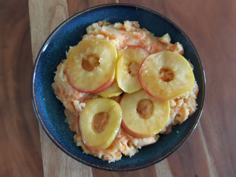Hutspot met gekarameliseerde appels op een bord van bovenaf