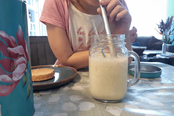Mijn dochter terwijl ze de bananenmilkshake drinkt tijdens de lunch