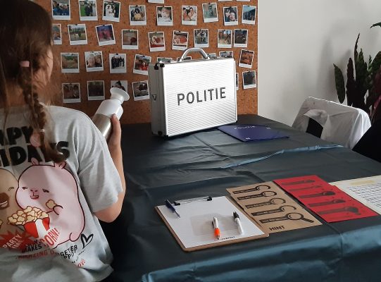 Mijn dochter zet spullen in de kamer neer om onze woonkamer te veranderen in een escape room