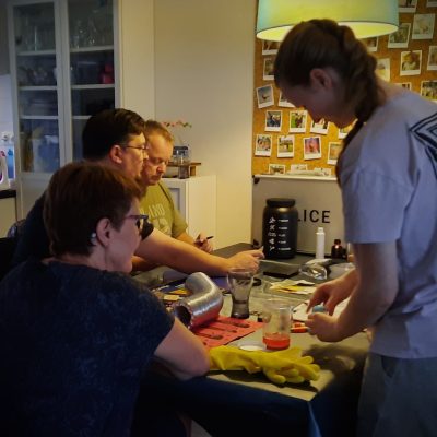 tijdens het spel: je ziet vier van de vijf speurneuzen die puzzels oplossen en spelmaterialen op tafel bekijken