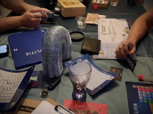 Een tafel vol spelmaterialen uit het spel Voorhovens Vennootschap van Codekrakers